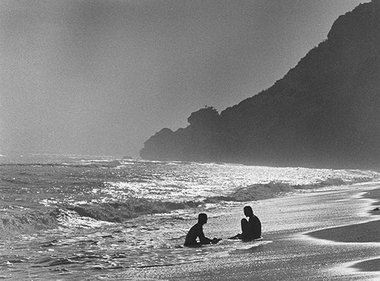 Surfers in the ocean in black and white